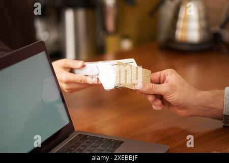 Close up cropped shot, male hand holding credit card, paying contactless by pressing it to the POS terminal, making purchase, co Stock Photo