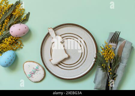 Table setting for Easter dinner with easter eggs and mimosa on a pastel background. Stock Photo