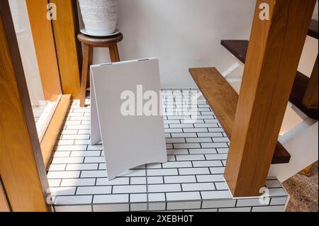 Mock up blank white notice signboard standing on the floor in wooden house Stock Photo