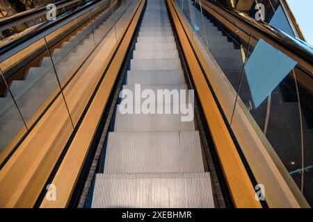 Modern way down automatic escalator with handrail and grass in department store Stock Photo