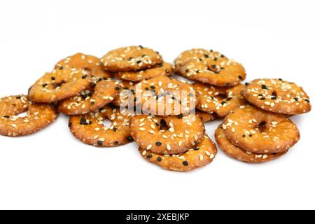 Salted round pretzels with black and white sesame isolated on white. Cracker chips with sea salt isolated on white background. Round shape appetizers. Stock Photo