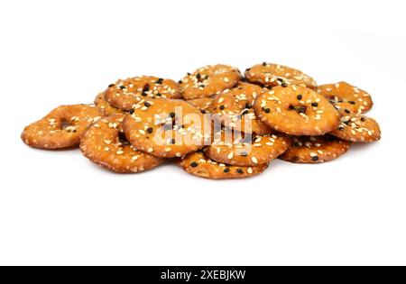 Salted round pretzels with black and white sesame isolated on white. Cracker chips with sea salt isolated on white background. Round shape appetizers. Stock Photo