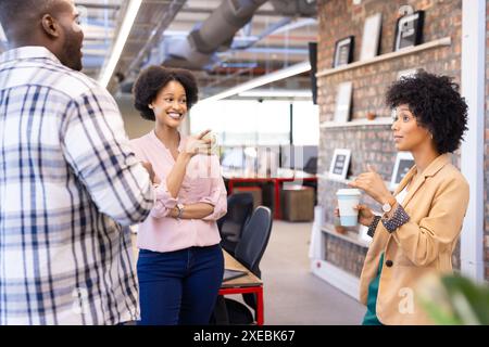 Having casual conversation and drinking coffee, African American business colleagues in office Stock Photo