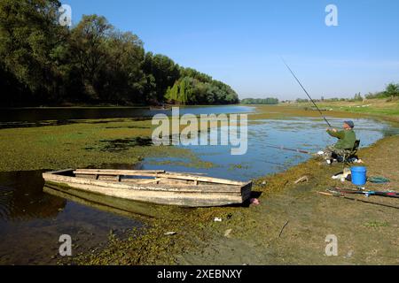 man fishing from the shore of Special Nature Reserve "Koviljsko-Petrovaradinski Rit" on the left bank of the Danube River, Vojvodina, Serbia Stock Photo