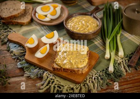 Egg salad spread being served with sliced hard boiled eggs and green onions Stock Photo