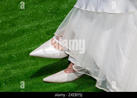 Bridal Elegance: Classic White Wedding Shoes on Lush Green Stock Photo