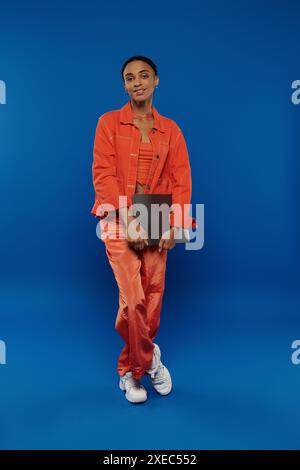 Woman In Orange Prison Jumpsuit With Handcuffs Against Grey Background