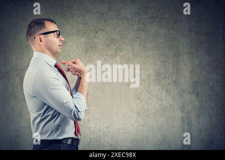 Side profile of a middle aged business man pointing fingers at himself being in denial Stock Photo