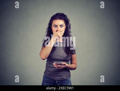 Worried stunned woman just read bad news on her smart phone Stock Photo
