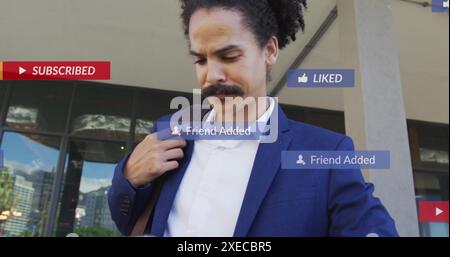 Image of social media icons with texts over biracial businessman using tablet Stock Photo
