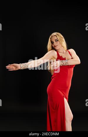 Young woman elegantly striking a pose in a vibrant red dress. Stock Photo