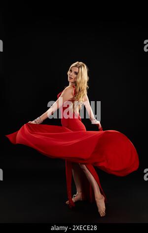 A lady in a red dress gracefully posing. Stock Photo