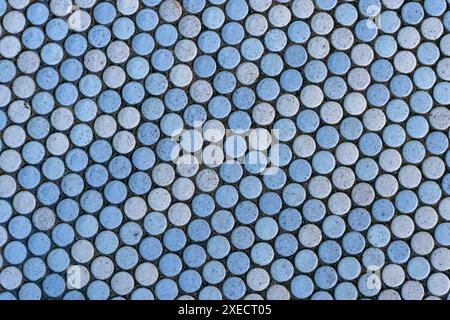 Abstract background with round ceramic tiles with mainly light blue, but also tiles in other pastel colors. Stock Photo