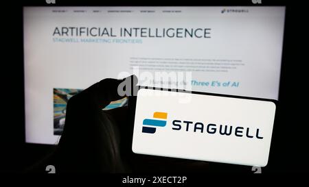 Person holding cellphone with logo of US marketing and communications company Stagwell Inc. in front of business webpage. Focus on phone display. Stock Photo