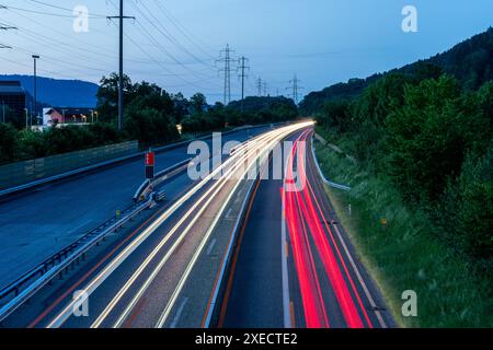 Highway with light trails of passing cars during dusk. Light trails are getting brighter with the dusk setting in. Long time exposures. Scene with hig Stock Photo