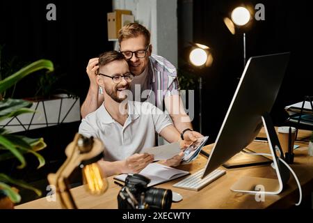 Two loving men engrossed in a laptop screen. Stock Photo