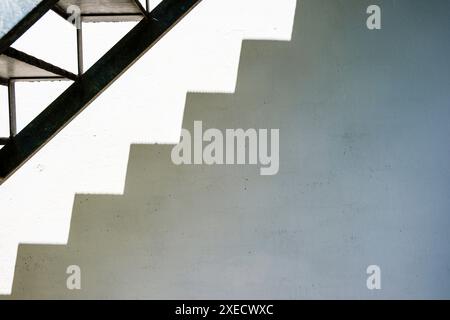 A metal staicase on the side of a white painted building. Stock Photo