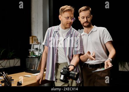 Two men in casual attire standing side by side, engrossed in a collaborative work project. Stock Photo