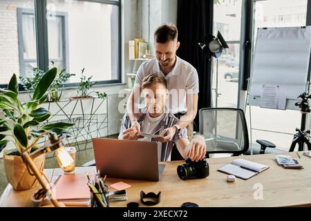 Two loving men engrossed in laptop screen. Stock Photo