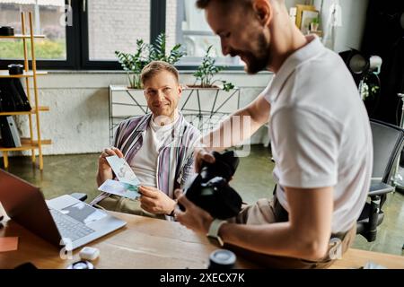 Happy couple working together at a table in an office setting. Stock Photo