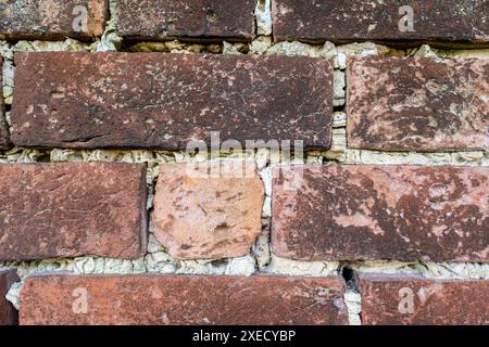 Old weathered brick wall in need of repointing in rural British village Stock Photo