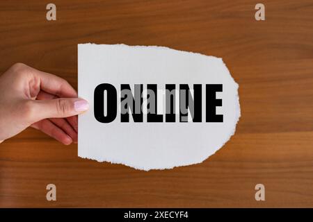Online Online. Woman hand holds a piece of paper with a note, online. Social media, internet, blogging, e-commerce, influencer. note B1983 online Stock Photo