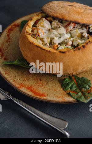 Pork medallions with mushroom sauce in bread pot Stock Photo