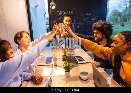 Startup Team High-Five Celebrating Success in Modern Office Stock Photo