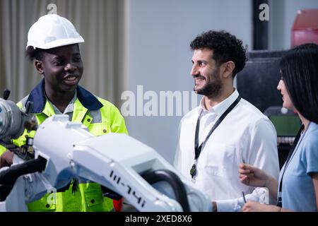 Technicians are introducing industrial hand robots to businessperson of factory industry who will use them in large-scale comple Stock Photo