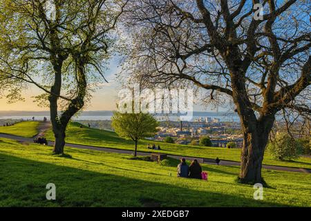 People on the Calton Hill park at sunset in spring with Leith district at the far end, city of Edinburgh in Scotland, UK. Stock Photo