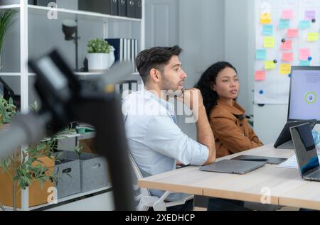 Multiethnic startup business team on meeting in modern bright office interior brainstorming, working on laptop and tablet comput Stock Photo