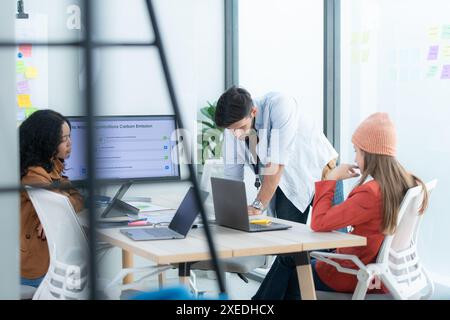 Multiethnic startup business team on meeting in modern bright office interior brainstorming, working on laptop and tablet comput Stock Photo