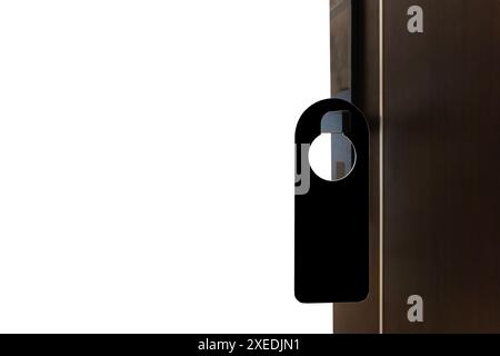 A black door hanger is hanging on a white door. The door hanger is smooth and has a beveled edge. The door hanger has a silver hook that is used to ha Stock Photo