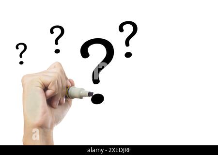 A hand holding a marker and writing question marks on a white background. The question marks are large, continuous motion. Question concept. Stock Photo