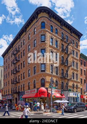 NYC Chinatown: 116 Mott Street, a six-story walk-up apartment building, has a rounded corner and white terra cotta details on its orange brick façade. Stock Photo