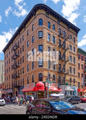 NYC Chinatown: 116 Mott Street, a six-story walk-up apartment building, has a rounded corner and white terra cotta details on its orange brick façade. Stock Photo