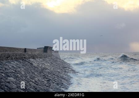 Porthcawl Lighthouse and breakwater at dawn on a rough winters morning Stock Photo