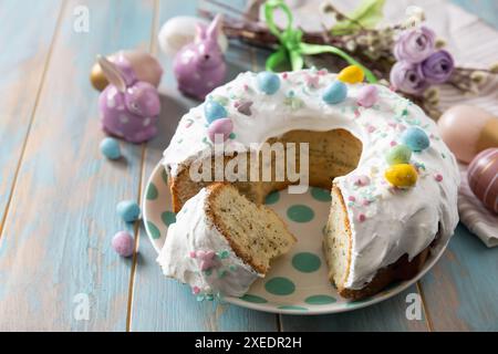 Glazed easter lemon cake decorated with confectionery and mini chocolate eggs candy on a wooden table. Stock Photo