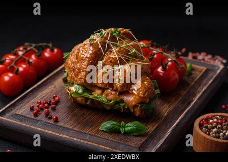 Delicious crispy croissant with salmon, lettuce, cheese and tomatoes Stock Photo