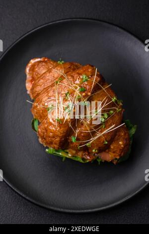 Delicious crispy croissant with salmon, lettuce, cheese and tomatoes Stock Photo