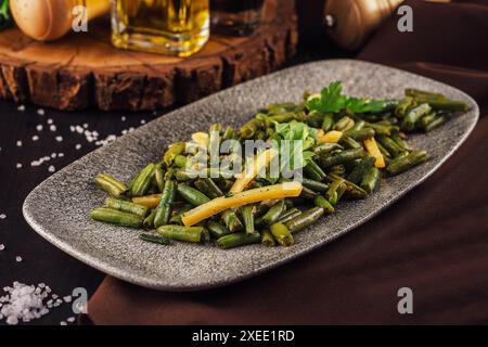 Fried wok green beans with onions and spices Stock Photo