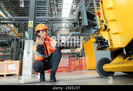 Female engineer working in electric train repair shop, Inspecting small grinding the railroad tracks machine before being put ou Stock Photo