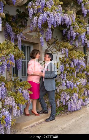 Portrait of a husband and wife on a flower background.Relationships in adulthood. Hugs and love. A beautiful couple. 45+ Stock Photo