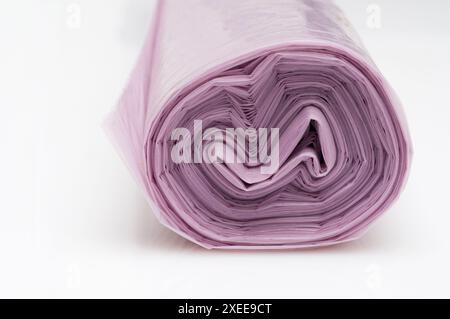 Roll of purple plastic garbage bags on white background Stock Photo