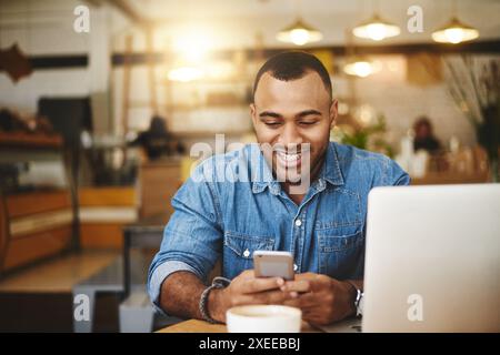 Man, cafe and smile typing on smartphone, smiling and message notification on mobile app with online searching. Communication, freelance writer and Stock Photo