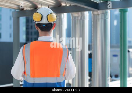 Back view of Engineers inspect the completed air conditioning and water systems to continue verifying their functionality. Stock Photo