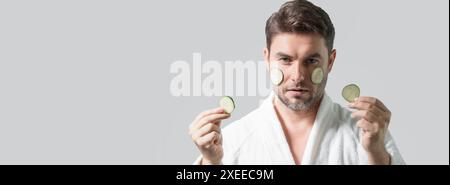 Banner of beauty man hold cucumber. Middle aged man with cucumber isolated on studio background. Cucumber for cosmetics skin mask. Facial mask with cu Stock Photo