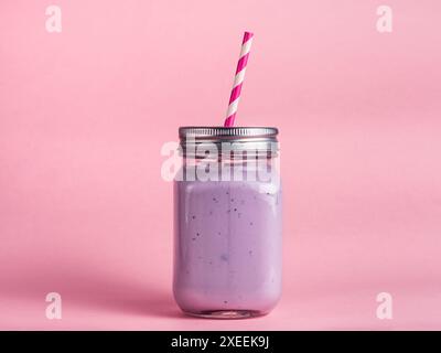 Blueberry smoothie in mason jar glass on pink Stock Photo