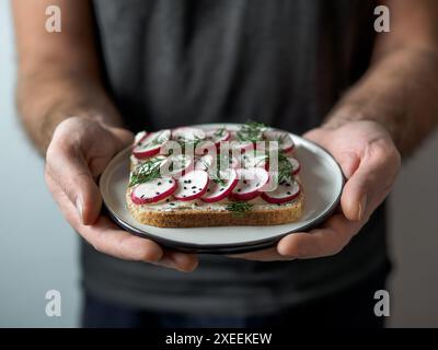 Vegan sandwich with radish in male hands Stock Photo