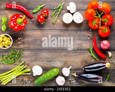 Vegetables and herbs on wooden table with copyspace in center Stock Photo
